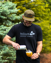 Load image into Gallery viewer, Male wearing black t-shirt with class Trillium logo
