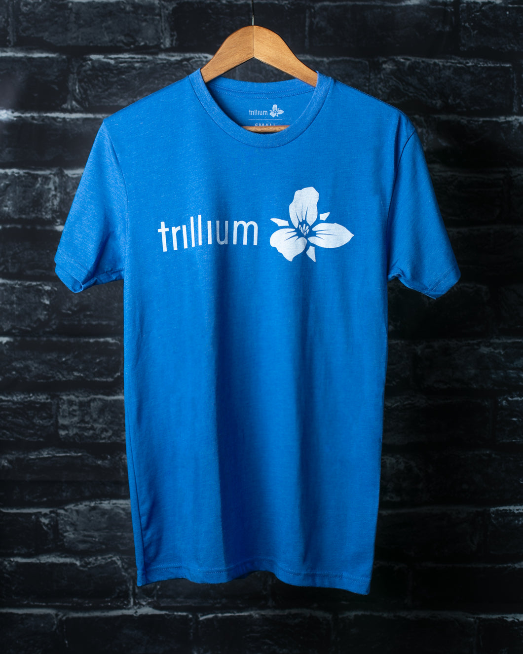 blue t-shirt with Trillium flower logo and horizontal text